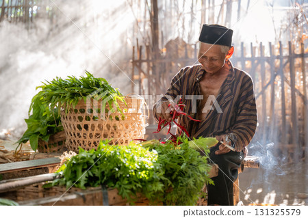 A Market Vendor is Skillfully Preparing Fresh Herbs While Surrounded by Enchanting Light A Market Vendor is Skillfully Preparing Fresh Herbs While Surrounded by Enchanting Light 131325579