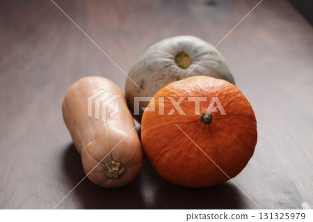 Different pumkins on walnut wood table Different pumkins on walnut wood table 131325979