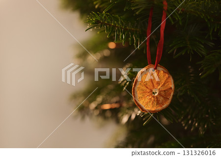 Dried orange as a decoration hanging on christmas tree Dried orange as a decoration hanging on christmas tree 131326016