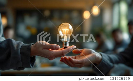 A person holding a light bulb, symbolizing ideas and collaboration in a brainstorming session or classroom setting 131326139