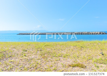 Summer coastal scenery overlooking the blue sea and breakwater 131327374