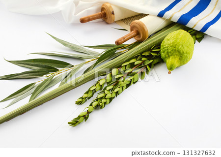 Jewish Holiday Symbols. A lulav, etrog, and Torah scroll on white cloth Jewish Holiday Symbols. A lulav, etrog, and Torah scroll on white cloth 131327632