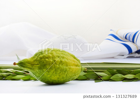 Sukkot Symbols. Yellow etrog with lulav branches on a Jewish prayer shawl symbolizing the Sukkot festival 131327689