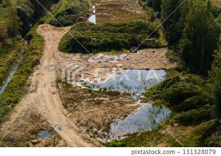A Beautiful Aerial View of a Diverse and Natural Landscape Featuring Ponds and Dirt Roads 131328079