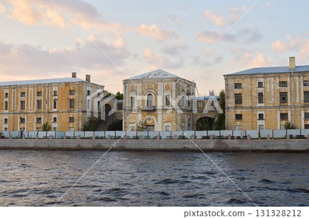 A magnificent historic building located beside the river at sunset, creating a striking scene 131328212