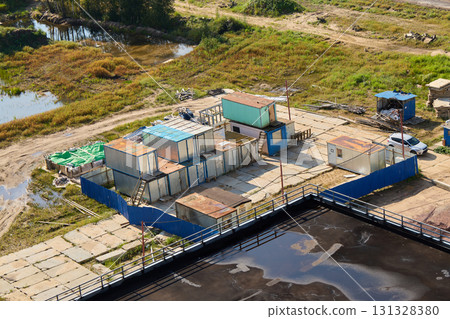 Birds Eye Aerial View of an Industrial Site Featuring Shipping Containers and a Body of Water 131328380