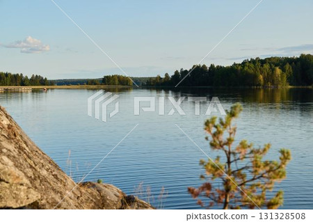 A Beautiful and Serene Lakeside View featuring Lush Greenery and Calm, Reflective Waters A Beautiful and Serene Lakeside View featuring Lush Greenery and Calm, Reflective Waters 131328508