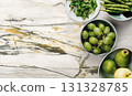 Fresh green vegetables and juicy fruits arranged on a marble surface for healthy cooking inspiration 131328785