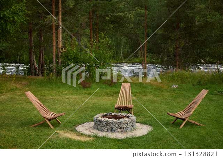 A Serene and Inviting Outdoor Fire Pit Area Surrounded by Lush Nature and Greenery A Serene and Inviting Outdoor Fire Pit Area Surrounded by Lush Nature and Greenery 131328821