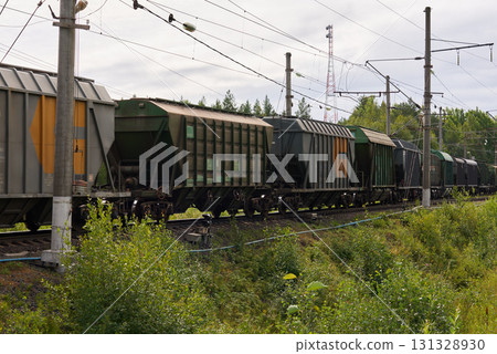 Freight Train Cars Loaded with Cargo Traveling on a Remote Rural Track in Natures Landscape 131328930