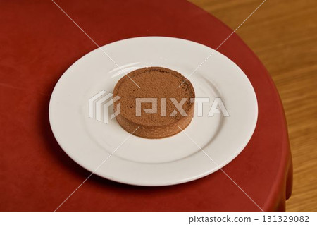 Indulge in a Delicious Chocolate Dessert That is Artfully Arranged on a Crisp White Plate Indulge in a Delicious Chocolate Dessert That is Artfully Arranged on a Crisp White Plate 131329082