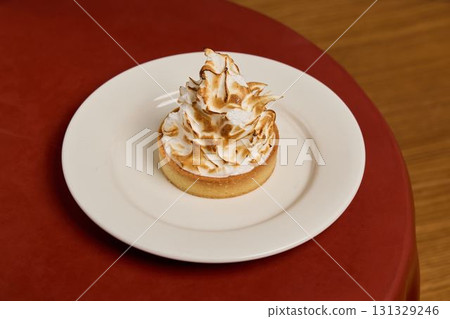Indulge in a Delicious Meringue Tart elegantly presented on a Beautiful Plate for Dessert Indulge in a Delicious Meringue Tart elegantly presented on a Beautiful Plate for Dessert 131329246