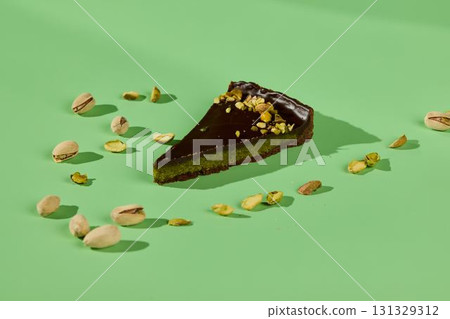 A Mouthwatering Slice of Delicious Chocolate Pistachio Cake Set Against a Green Background A Mouthwatering Slice of Delicious Chocolate Pistachio Cake Set Against a Green Background 131329312