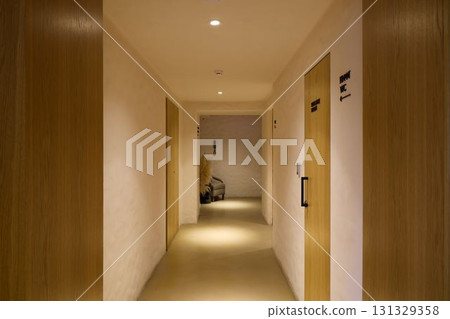 Modern Hotel Corridor Featuring Elegant Wooden Doors and Soft, Inviting Lighting Ambiance 131329358