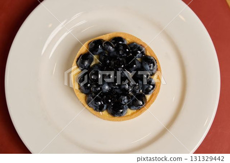 A Truly Delicious and Beautiful Blueberry Tart is Presented Elegantly on a Crisp White Plate 131329442