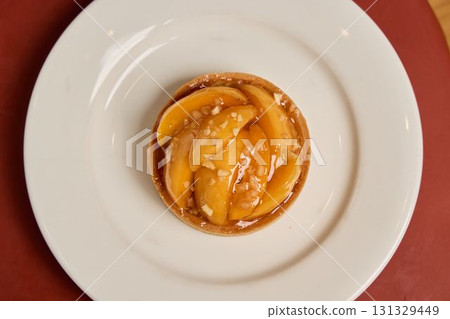 A Delicious Peach Tart beautifully presented on an Elegant White Plate for all to enjoy A Delicious Peach Tart beautifully presented on an Elegant White Plate for all to enjoy 131329449