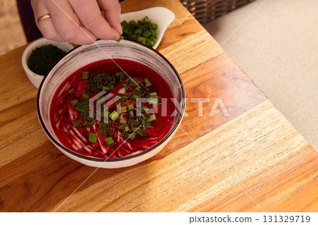 This vibrant beetroot soup, enriched with fresh herbs and green onions, is perfect for any meal 131329719
