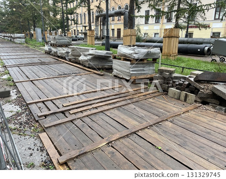 Urban Construction Pathway Featuring Wooden Planks and Various Construction Materials 131329745
