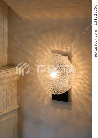 This elegant glass wall sconce features a unique light pattern that adds charm and sophistication This elegant glass wall sconce features a unique light pattern that adds charm and sophistication 131329750