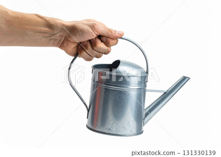 a metal watering can in a man's hand 131330139