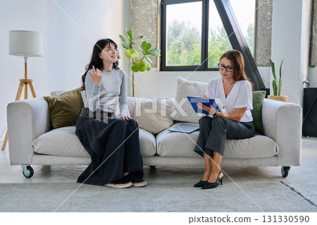 Young female patient in therapy session talking with female psychologist 131330590