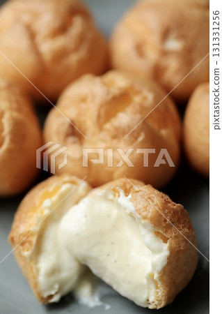 A cross section of a petit cream puff with a soft skin and plenty of cream 131331256