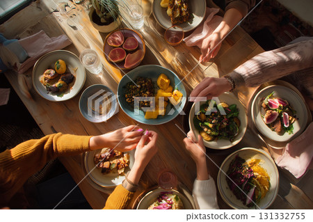 Brunch gathering with friends enjoying a colorful spread of delicious food Brunch gathering with friends enjoying a colorful spread of delicious food 131332755