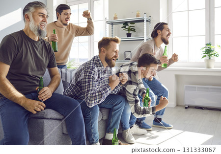 Group of excited friends watching football match on tv at home with beer. Group of excited friends watching football match on tv at home with beer. 131333067