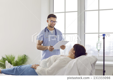 Nurse at clinic or hospital talks to woman patient who is getting intravenous infusion Nurse at clinic or hospital talks to woman patient who is getting intravenous infusion 131333098