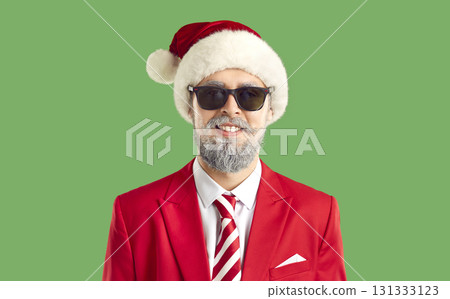 Portrait of a handsome young man in sunglasses and Santa Claus hat. 131333123