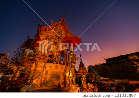 Time lapse In the evening, a golden Buddha and an ornate temple 131333807