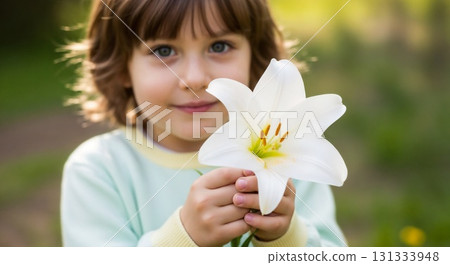 A smiling child holding a white lily. 131333948