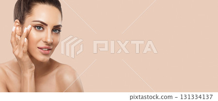 Beauty face model. Beautiful Woman with healthy smooth facial clean skin holding bottle cosmetic cream. Face Skin care Moisturizer Facial treatment. Panorama baner With Copy Space. 131334137
