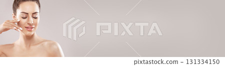 Half-naked brunette woman smiling andtouch own face isolated over grey background Half-naked brunette woman smiling andtouch own face isolated over grey background 131334150