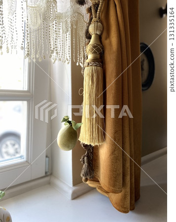 Elegant curtain with tassel and window view creates a luxurious home decor background Elegant curtain with tassel and window view creates a luxurious home decor background 131335164