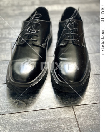 Black leather shoes on wooden floor, reflective surface creates elegant footwear background Black leather shoes on wooden floor, reflective surface creates elegant footwear background 131335165