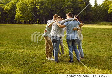 Group of people standing in circle in middle of green park and hugging each other. Group of people standing in circle in middle of green park and hugging each other. 131335228