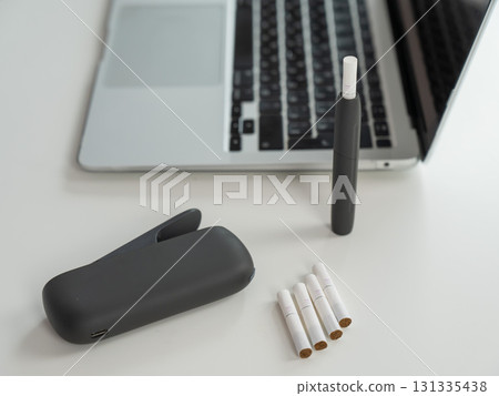 Tobacco heating system next to a laptop.  131335438