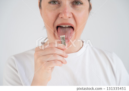 Woman Chewing Nicotine Snus Product. Woman Chewing Nicotine Snus Product. 131335451