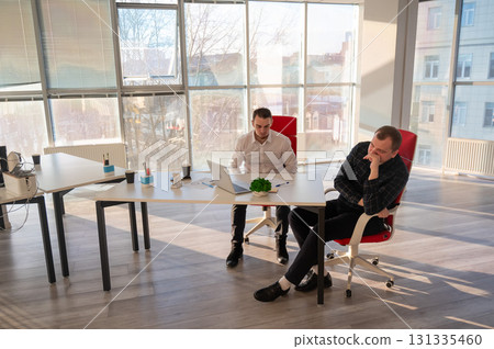 Two Caucasian men solve problems at work. Two Caucasian men solve problems at work. 131335460