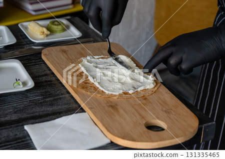 The cook prepares a fruit roll from pancakes.  131335465