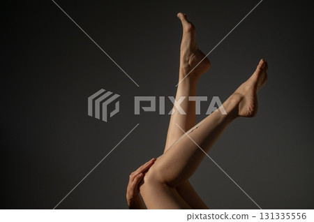 Woman applying moisturizer to her legs.  131335556