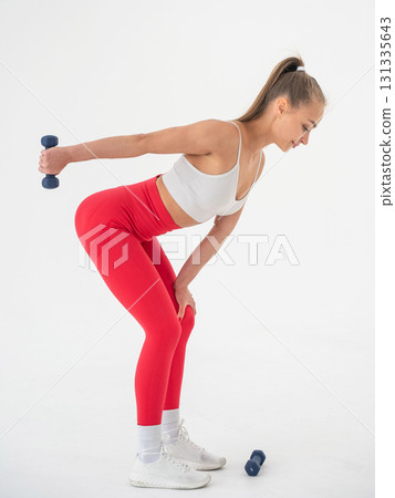 Young woman doing exercise with dumbbells on white background. Young woman doing exercise with dumbbells on white background. 131335643