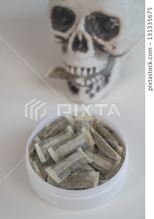 Skull Chewing Tobacco on a White Table. 131335675