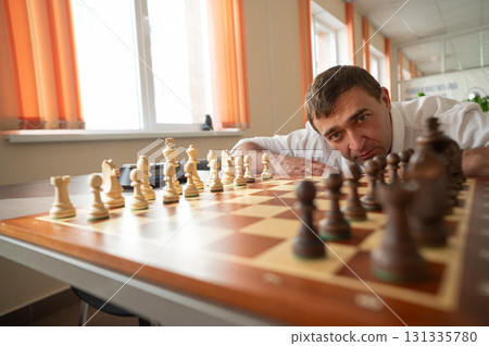 Middle aged Caucasian man playing chess.  Middle aged Caucasian man playing chess.  131335780