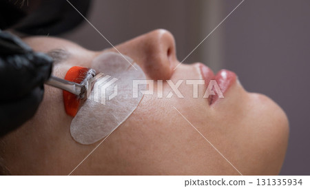 Caucasian woman undergoing eyelash lamination procedure.  131335934
