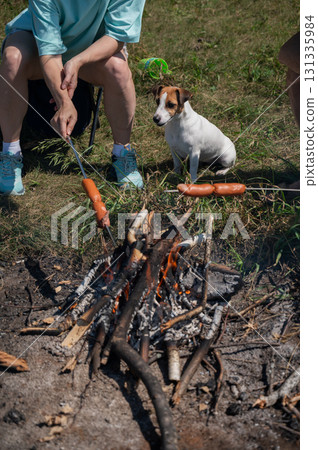 Caucasian couple roasting sausages over a fire. Caucasian couple roasting sausages over a fire. 131335984