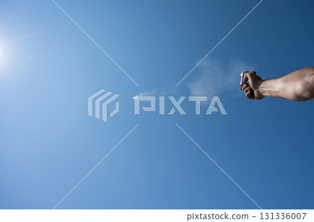 A man fires a flare gun with emergency fire. Close-up of a man's hand. A man fires a flare gun with emergency fire. Close-up of a man's hand. 131336007