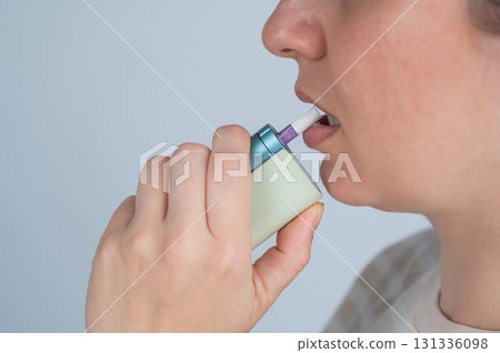 Caucasian woman smoking electronic cigarette. Tobacco heating system. 131336098