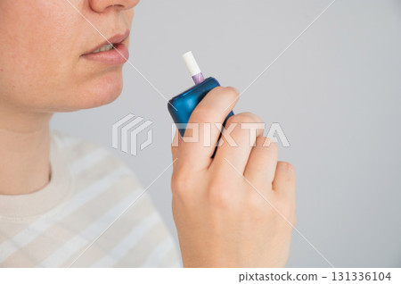 Caucasian woman smoking electronic cigarette. Tobacco heating system. 131336104